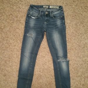 Cuffed, faded light blue jeans with holes